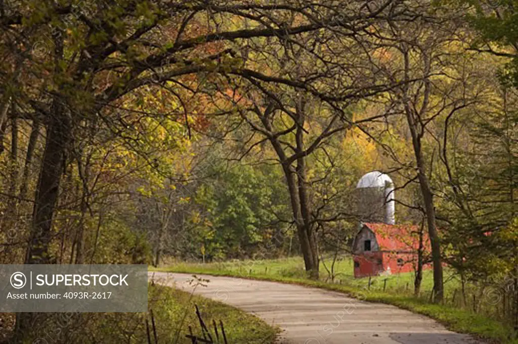 Valley road past red barn in fall woods, southwest Wisconsin