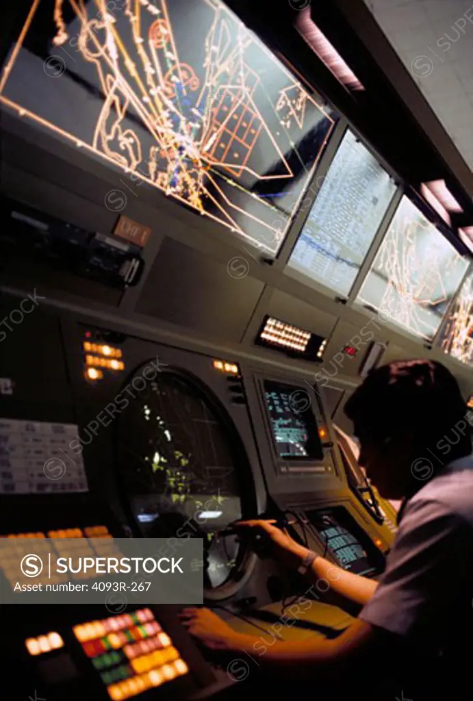 Air Traffic Controllers ( ATC ) working at an FAA facility. Monitors overhead show aircraft traffic.