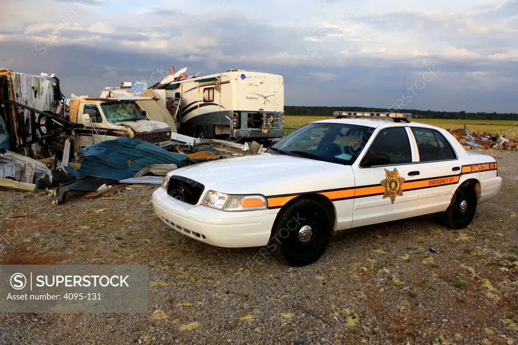 Sheriff deputy's vehicle sites near the wreckage of a storage building damaged by tornado, Tanner, Limestone County, Alabama, USA