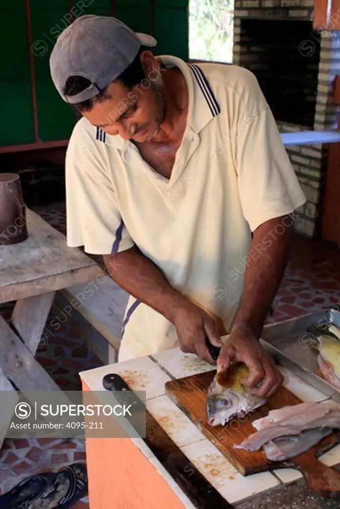 Brazil, Man filleting fish