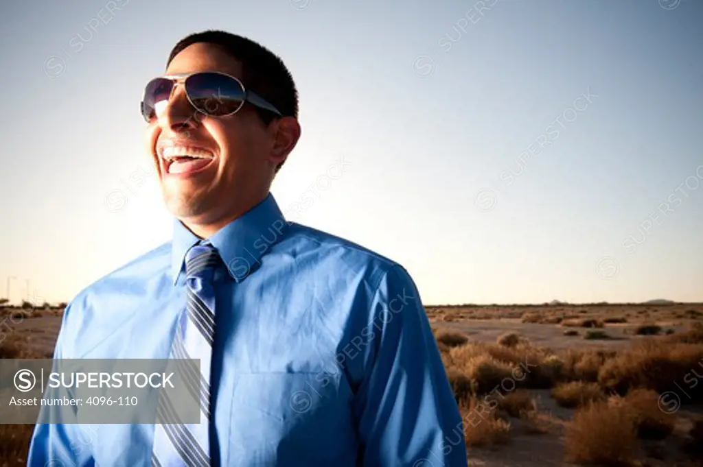 Businessman laughing in a desert