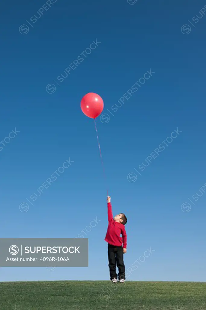 Boy standing with a small balloon