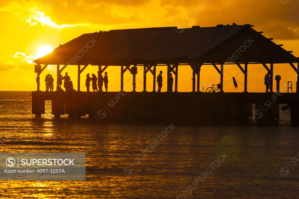 Tourists enjoying at a pier, Na Pali Coast, Hanalei, Kauai, Hawaii, USA