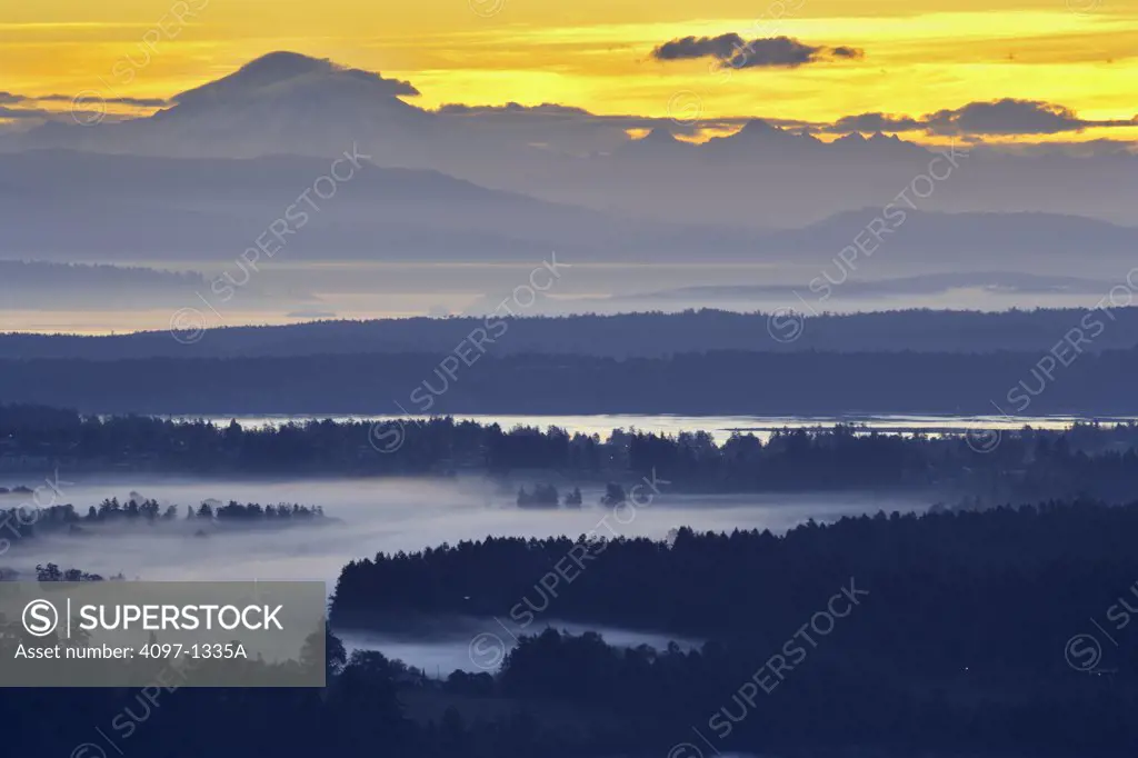 Mountain range and trees covered with fog at sunrise, Mt Baker, Haro Strait, Saanich Peninsula, Vancouver Island, British Columbia, Canada