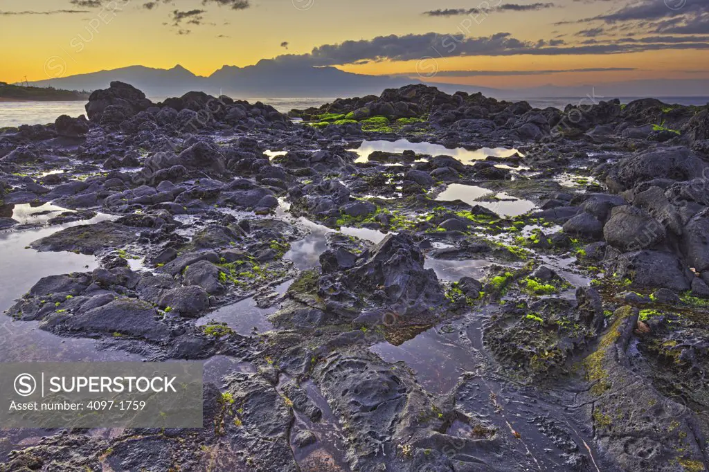 Rock formations with mountains in the background, North Maui Mountains, Hookipa Beach, Maui, Hawaii, USA