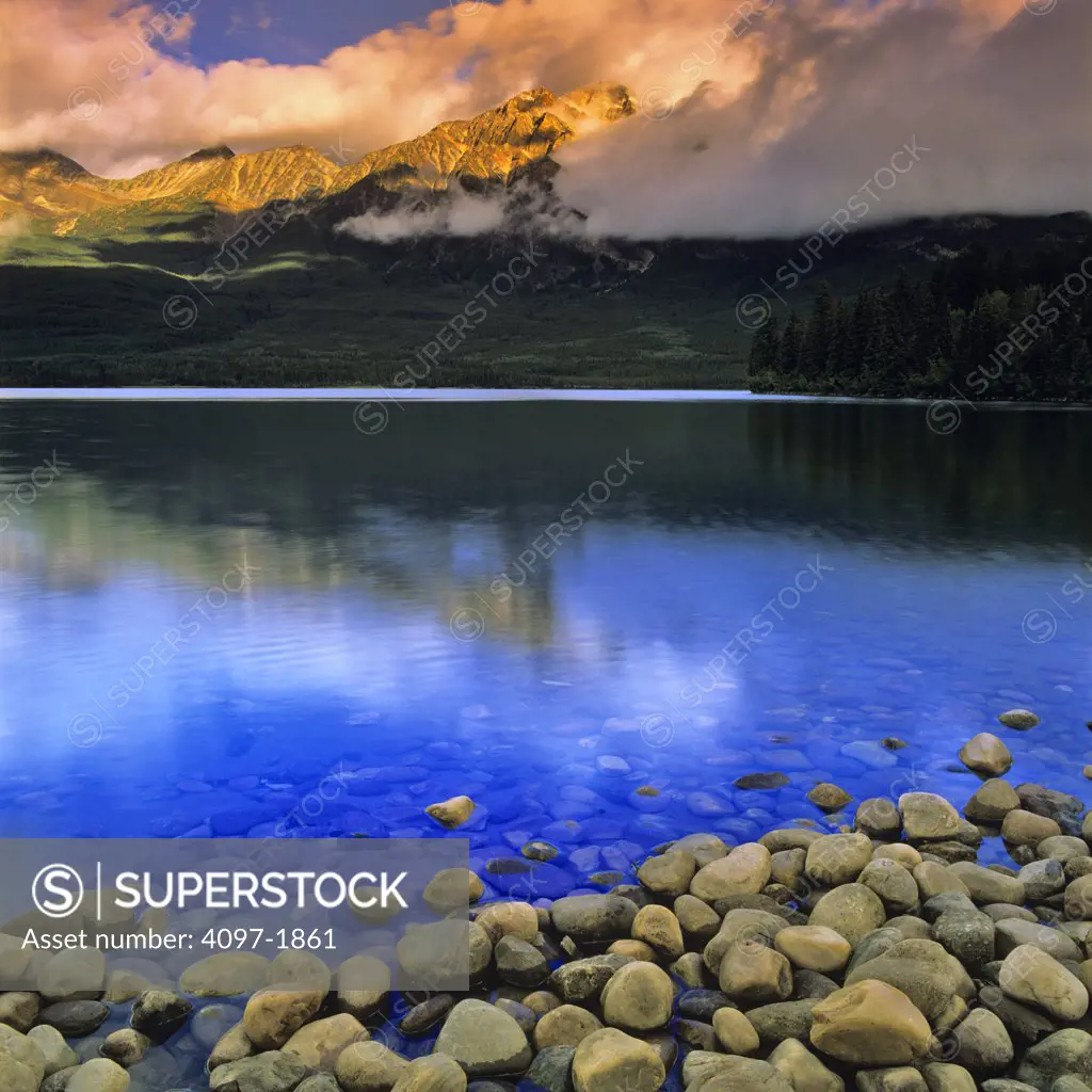 Stones in a lake with mountains in the background, Pyramid Lake, Pyramid Mountain, Jasper National Park, Alberta, Canada