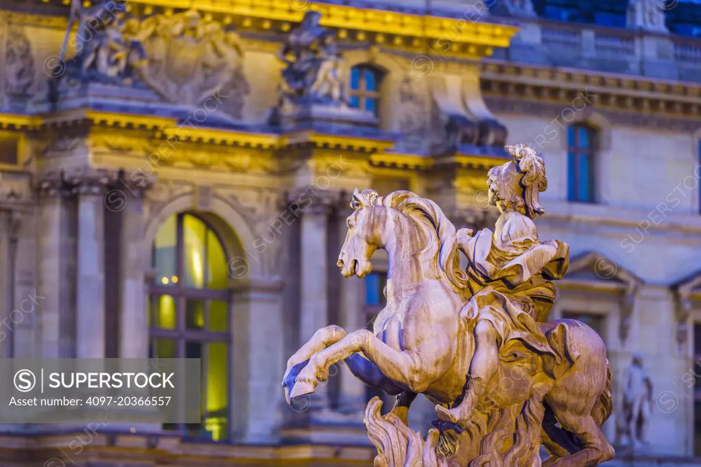 Louvre Museum courtyard with statue at dusk, Paris
