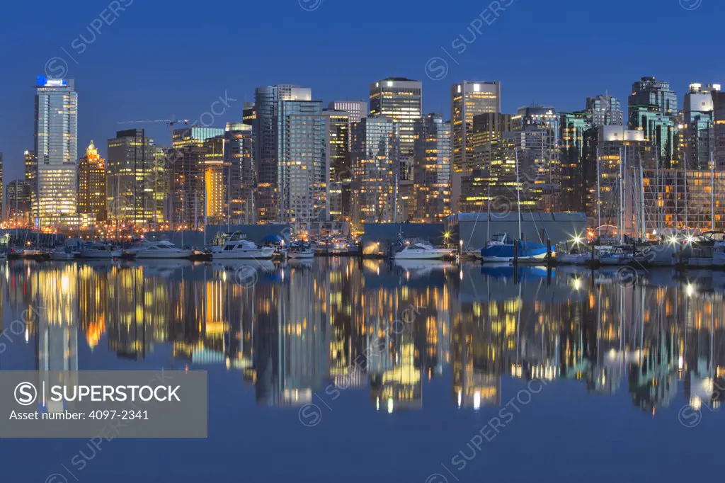 Skyscrapers in a city lit up at dusk, Coal Harbor, Vancouver, British Columbia, Canada