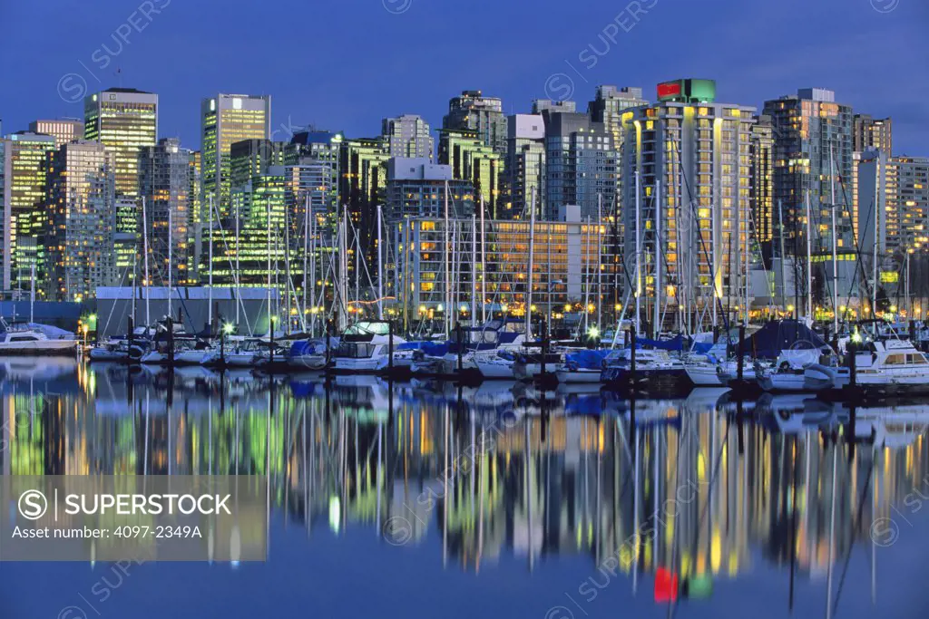 Skyscrapers in a city lit up at dusk, Coal Harbor, Vancouver, British Columbia, Canada