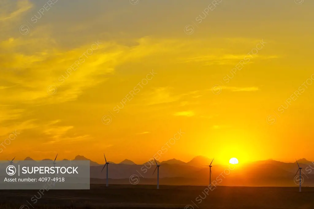 Canada, Alberta, Sunset over landscape with wind turbines