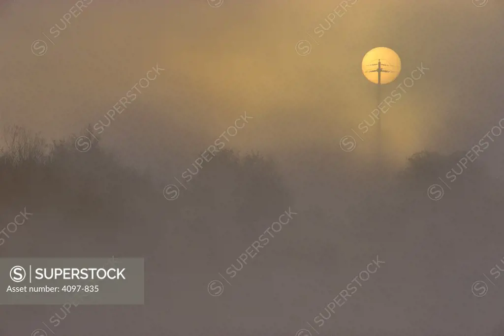 Electricity pylon in front of sun, Vancouver Island, British Columbia, Canada