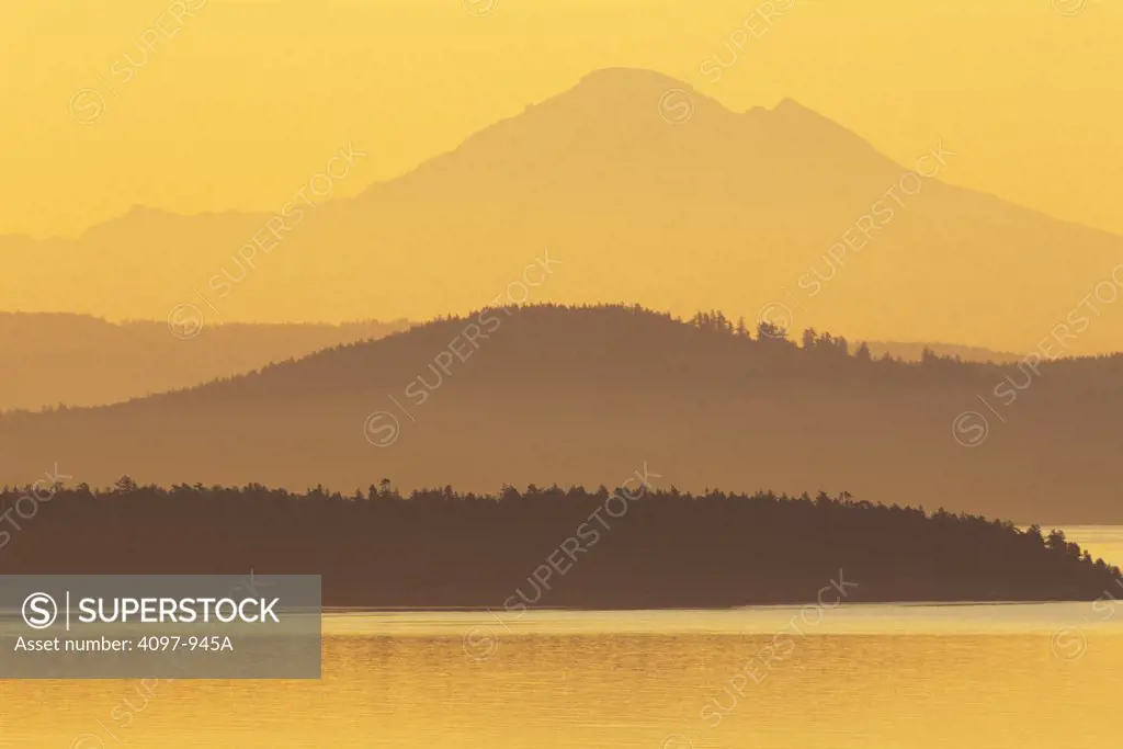 Island with mountain peak in the background, San Juan Island, Mt Baker, Haro Strait, Saanich Peninsula, Vancouver Island, British Columbia, Canada