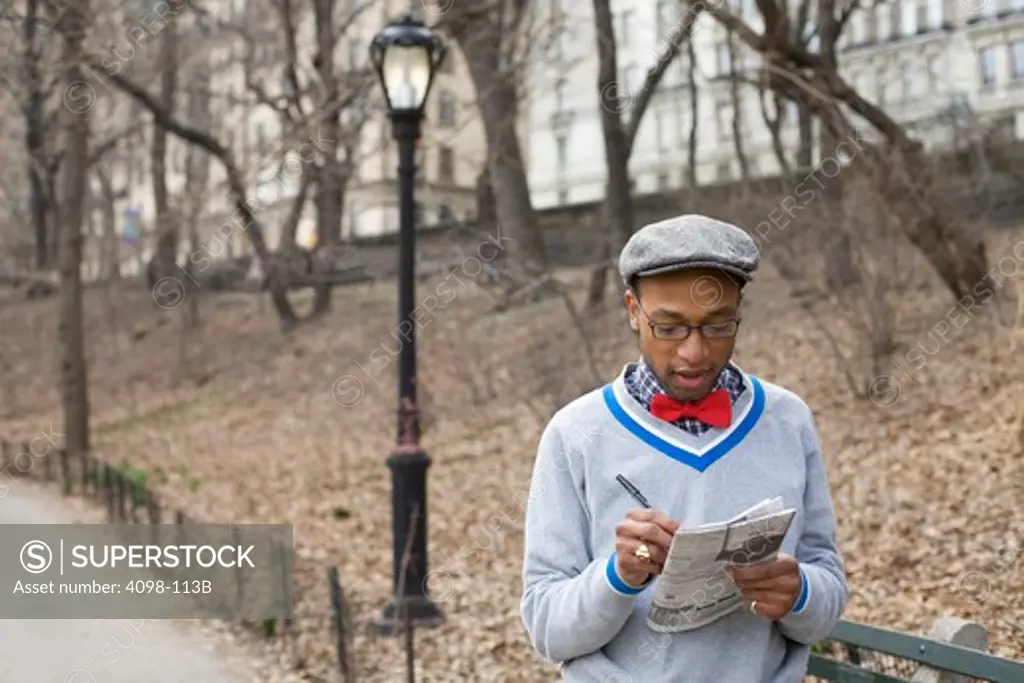 Man reading a newspaper in a park, Central Park, Manhattan, New York City, New York State, USA