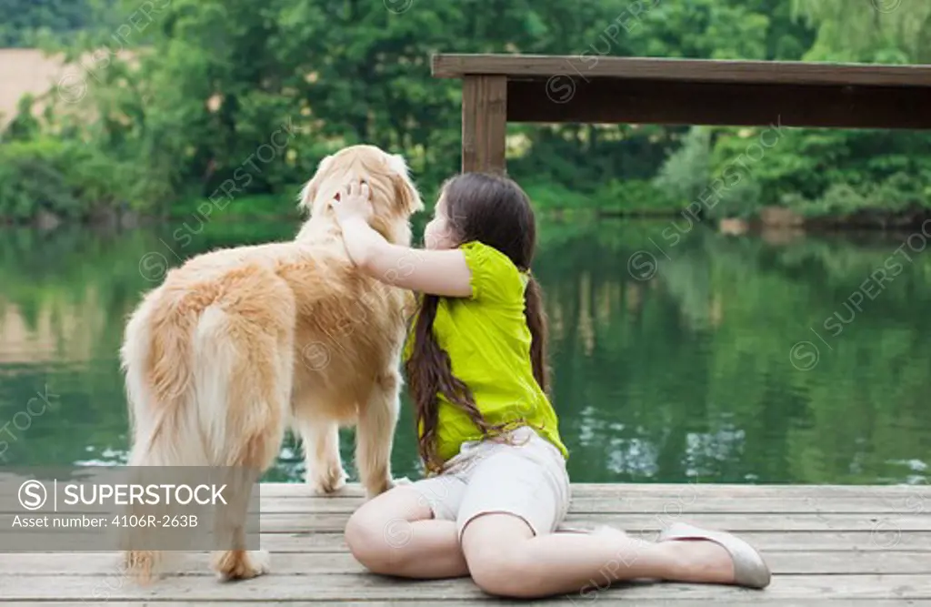 Girl with Golden Retriever on jetty