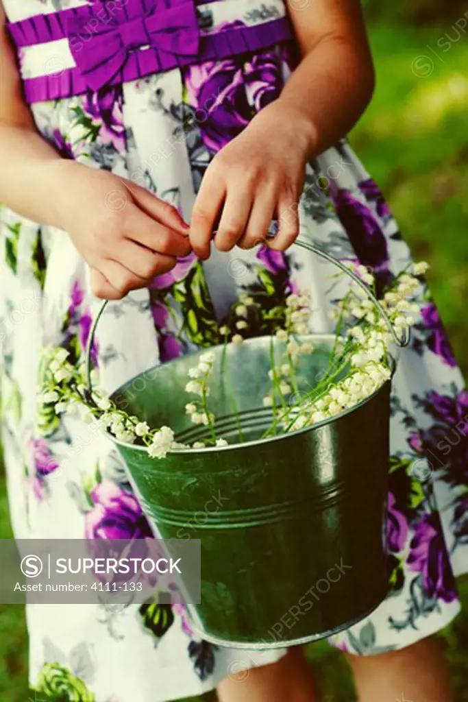 Mid section view of a flower girl holding flowers