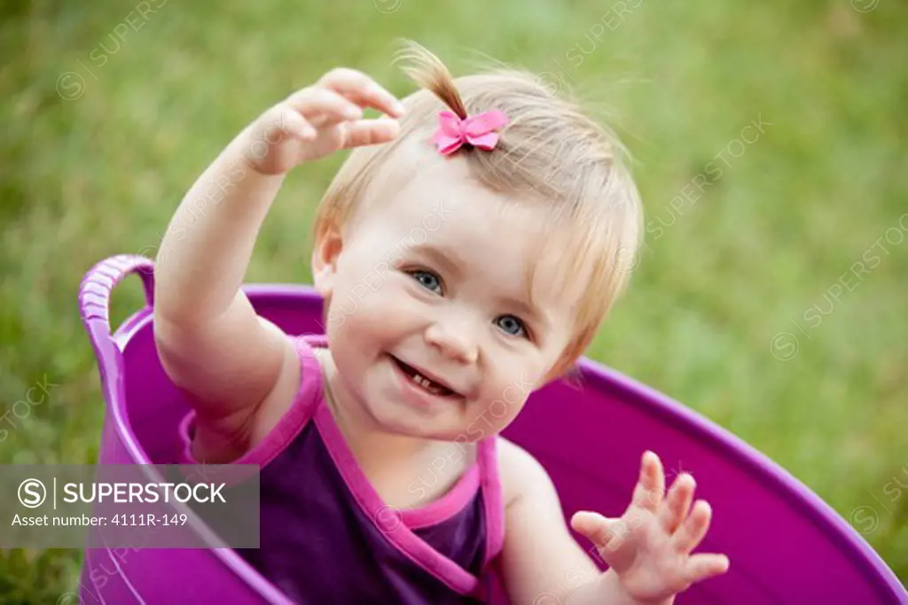 Portrait of a baby girl smiling in a bathtub, Traverse City, Grand Traverse County, Michigan, USA