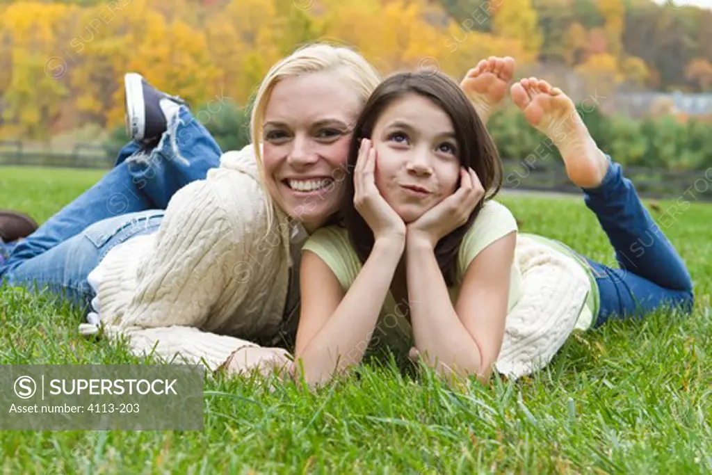 Portrait of mother and daughter lying on grass