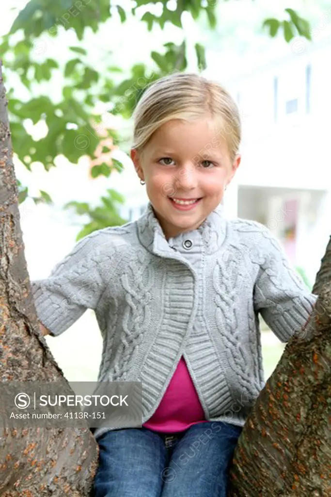 Girl sitting on a tree in a park