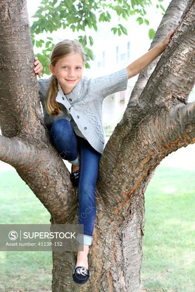Girl sitting on a tree in a park