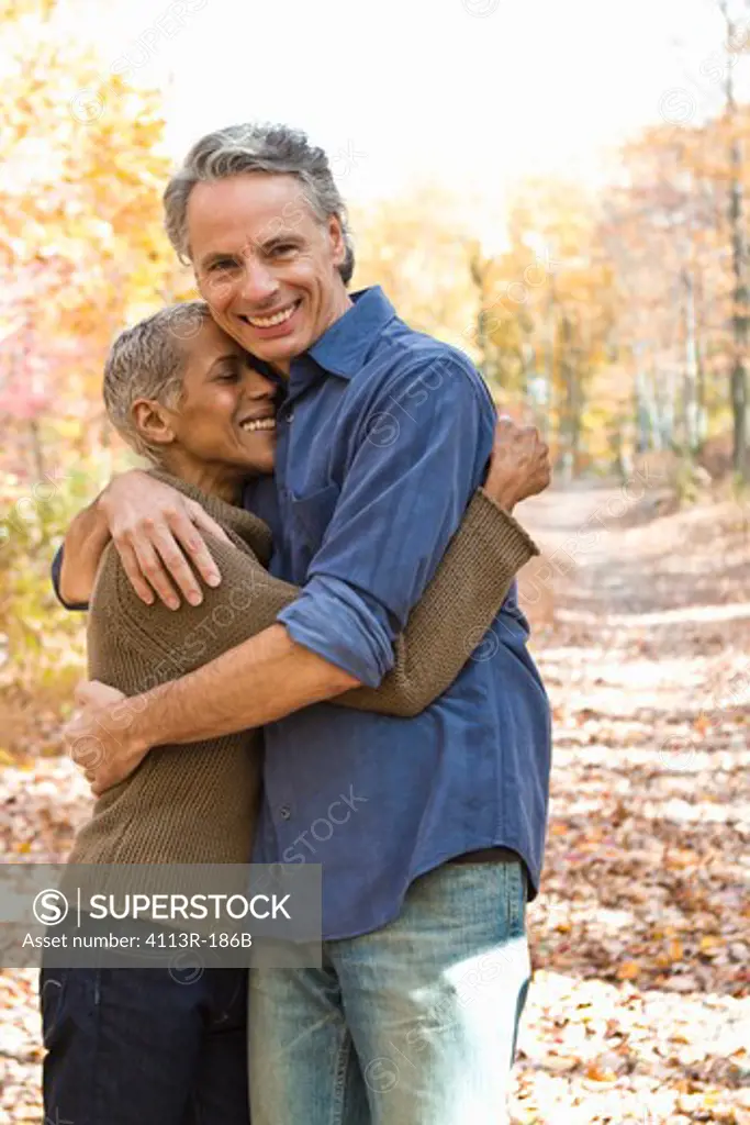 Portrait of mature couple standing on Autumn forest track