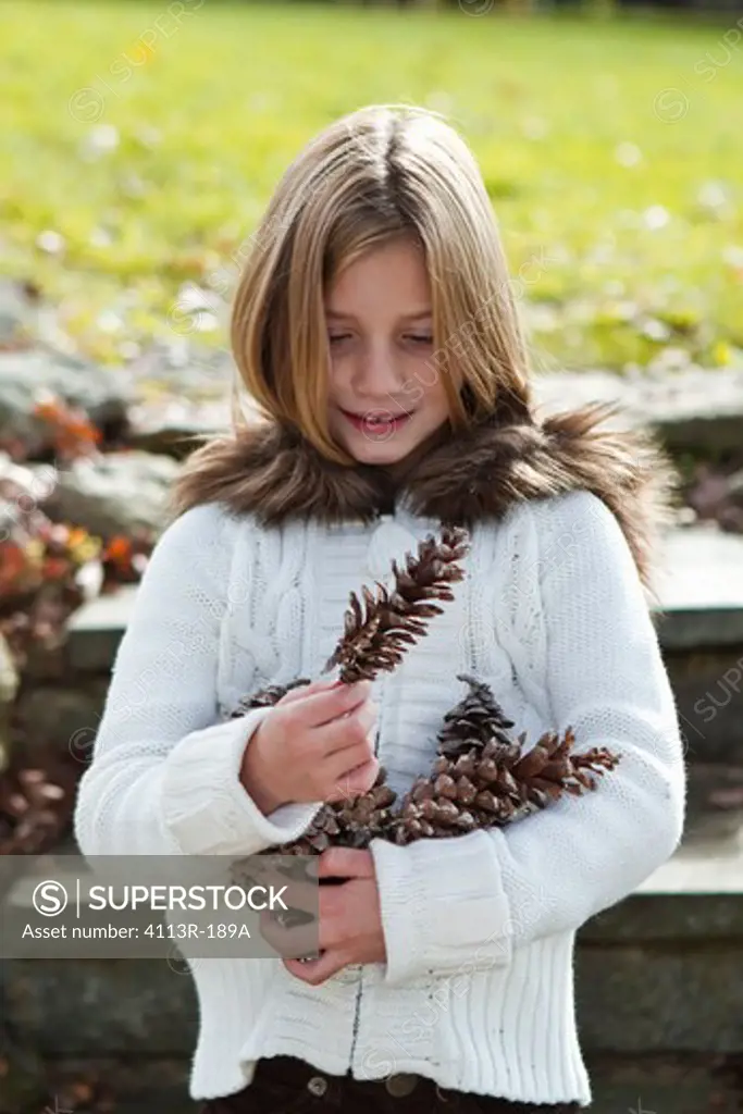 Portrait of girl holding pinecones
