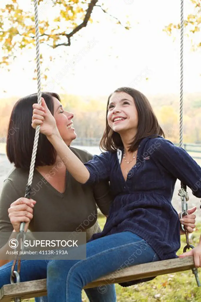 Mother with daughter on swing
