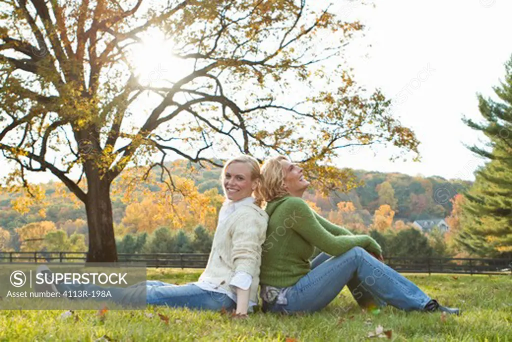 Two women sitting on field