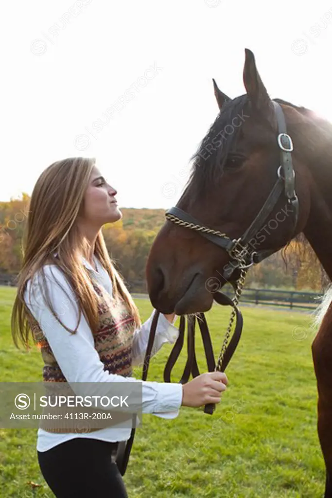 Teenage girl with horse on field