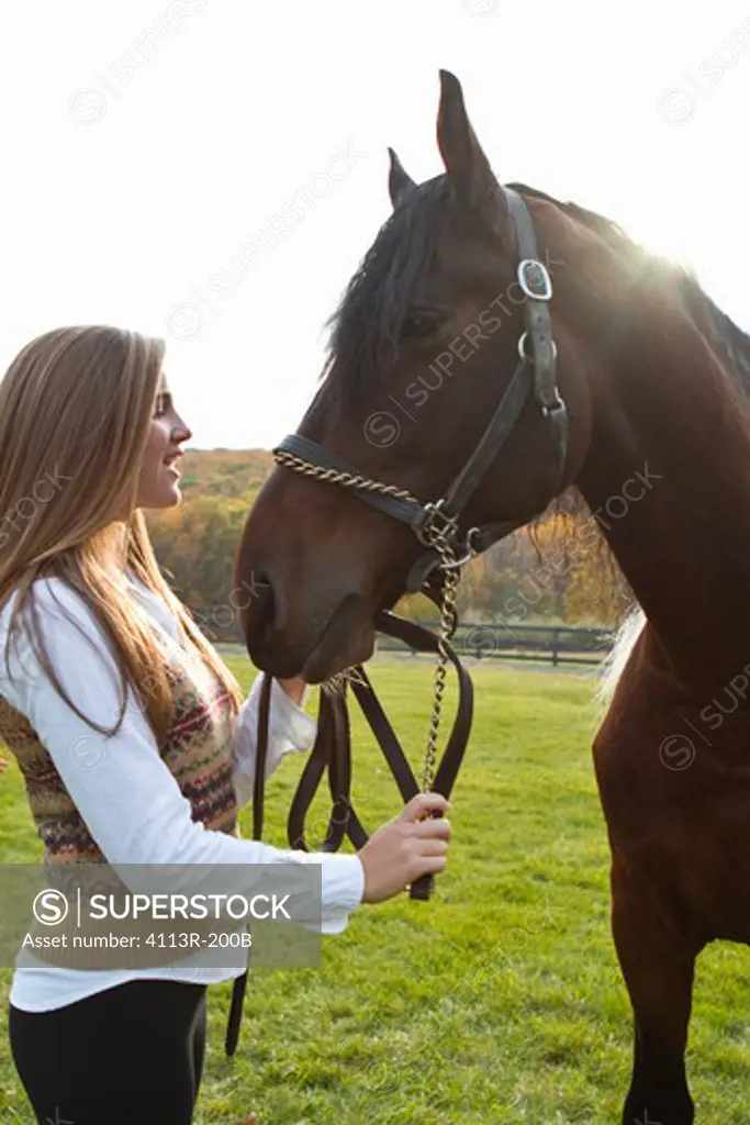 Teenage girl with horse on field