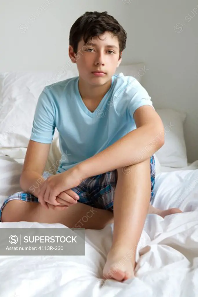 Portrait of boy sitting on bed