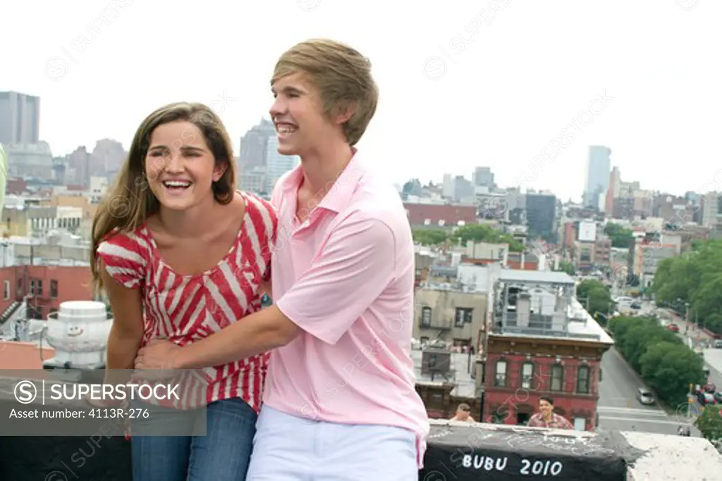 USA, New York, Manhattan, Teenage couple embracing on rooftop
