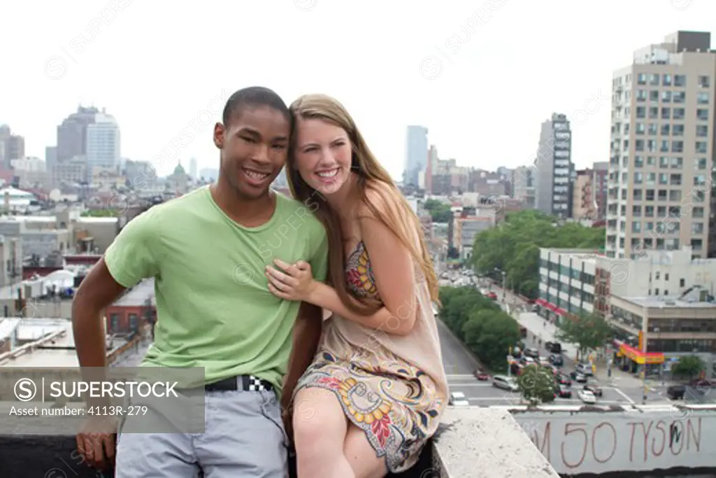 USA, New York, Manhattan, Teenage couple embracing on rooftop