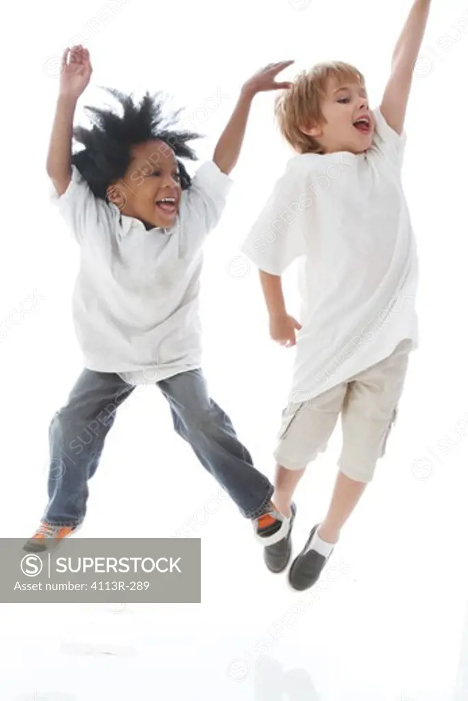 Studio shot portrait of boys jumping and laughing