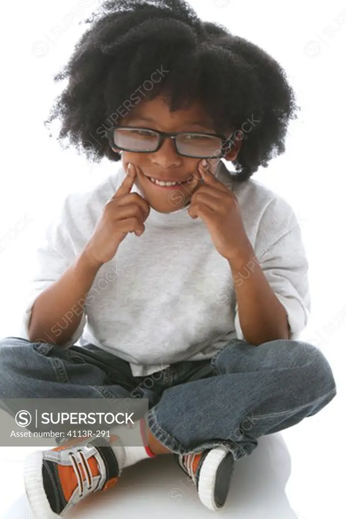 Studio shot portrait of boy with glasses seating and smiling