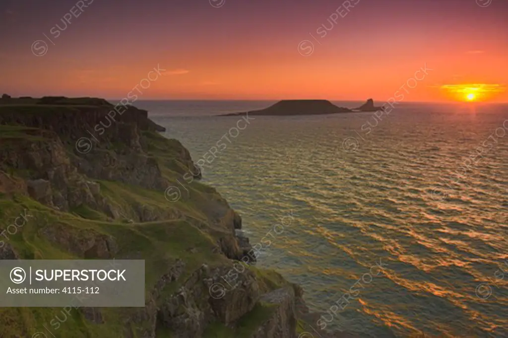 Sunset over Worms Head, Rhossili Bay, Gower Peninsula, West Glamorgan, South Wales, UK