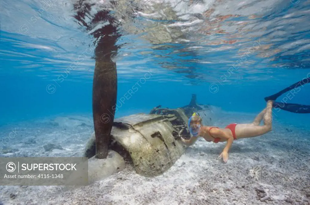 Woman snorkeling at Second World War Mitsubishi Zero plane near Peleliu island, Palau.