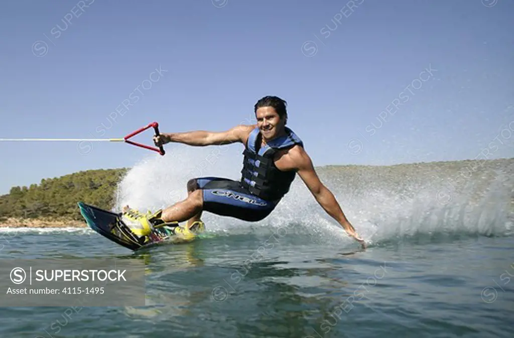 A wakeboarder leaning in and touching the water, Marverde, Turkey.