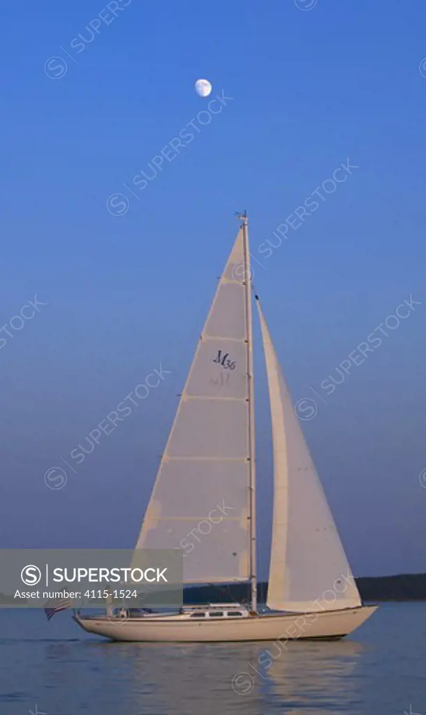 A Sparkman & Stephens designed Morris 36 sailing under the late afternoon sun with a full moon high above, Maine, USA
