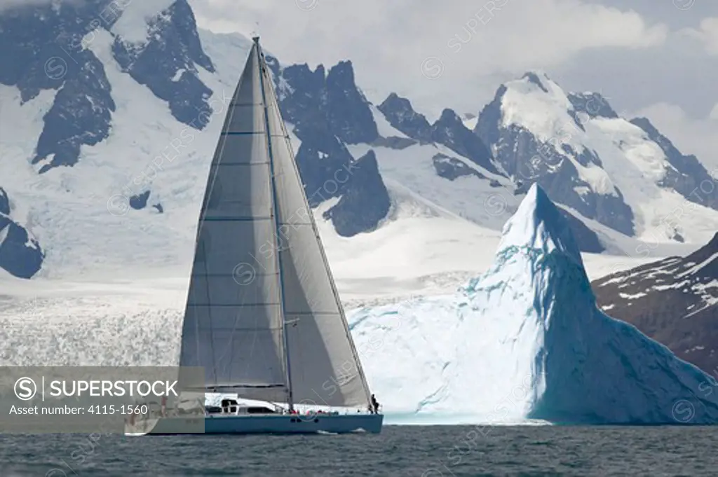The 88ft sloop 'Shaman' sailing under a backdrop of snow covered mountains and glaciers off the south coast of South Georgia