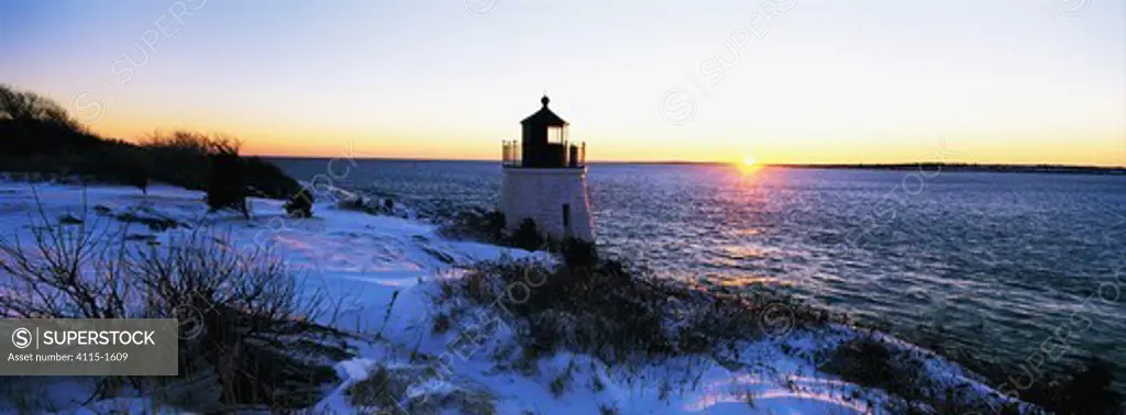 Castle Hill Lighthouse surrounded by snow under a wintery sunset. Established in 1890, the lighthouse marks the East Passage into Narragansett Bay, near Newport, Rhode Island, USA.
