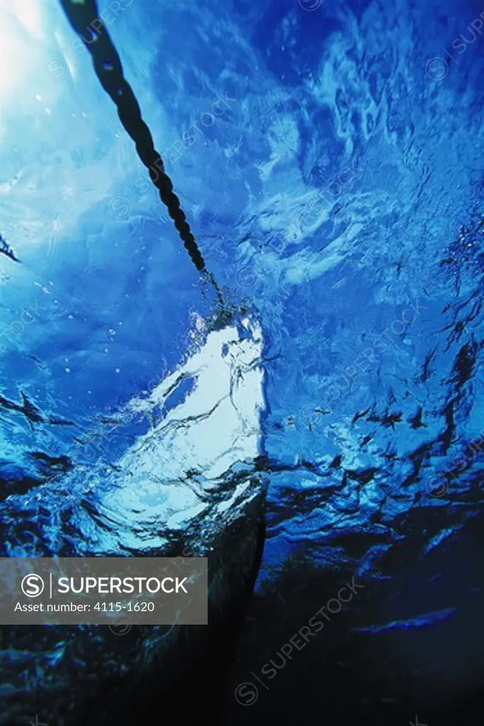 Underwater view of the bow and anchor chain of a cruising yacht.