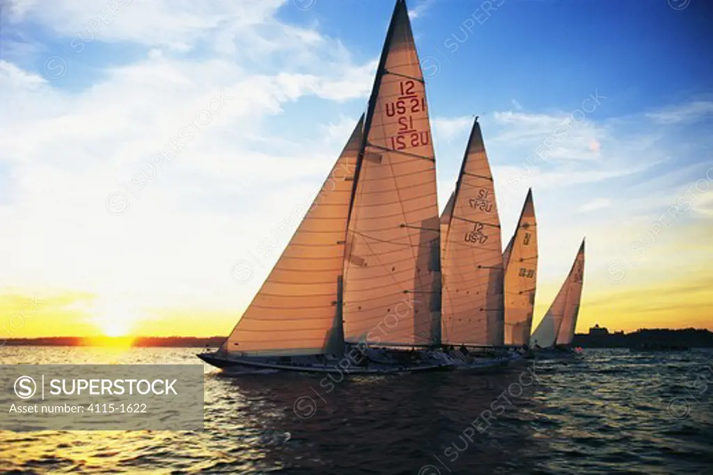 Fleet of 12m classics racing at sunset on Narragansett Bay, Newport, Rhode Island, USA. Property Released (four yachts).