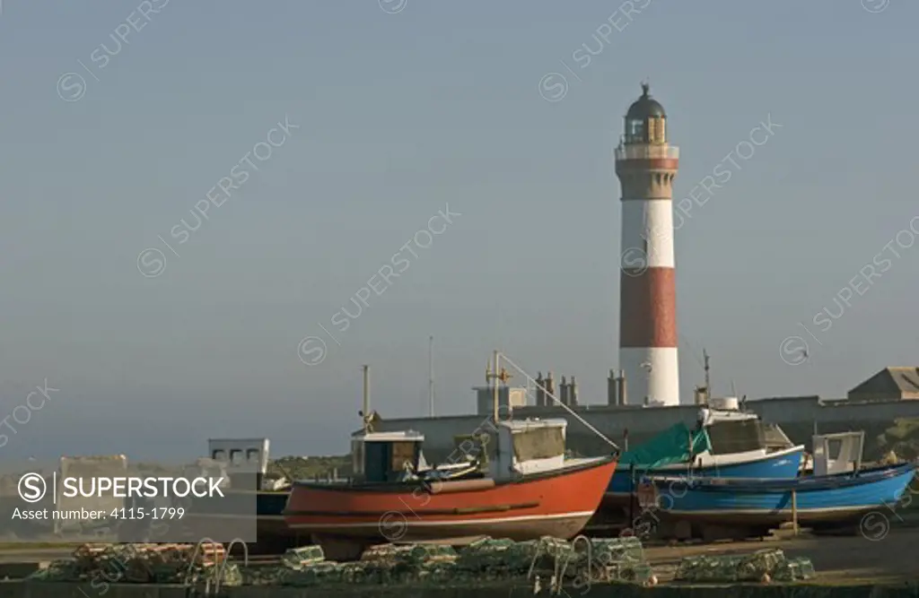 Buchanness lighthouse and boats pulled up onto the hard, North East Scotland. Spring 2005.