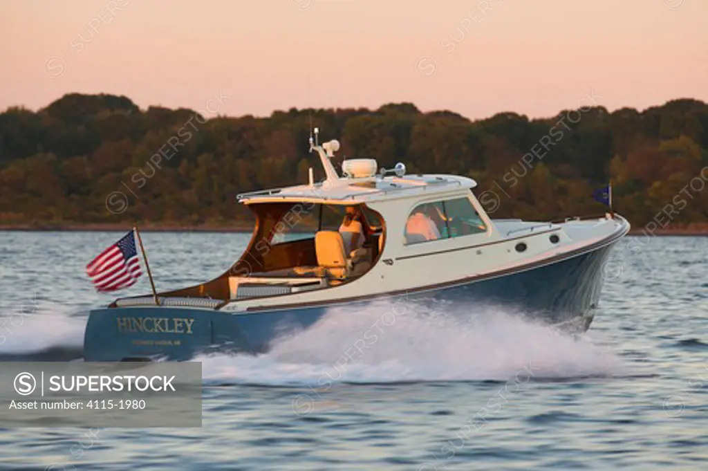 A Hinckley Picnic motorboat planing along the coast