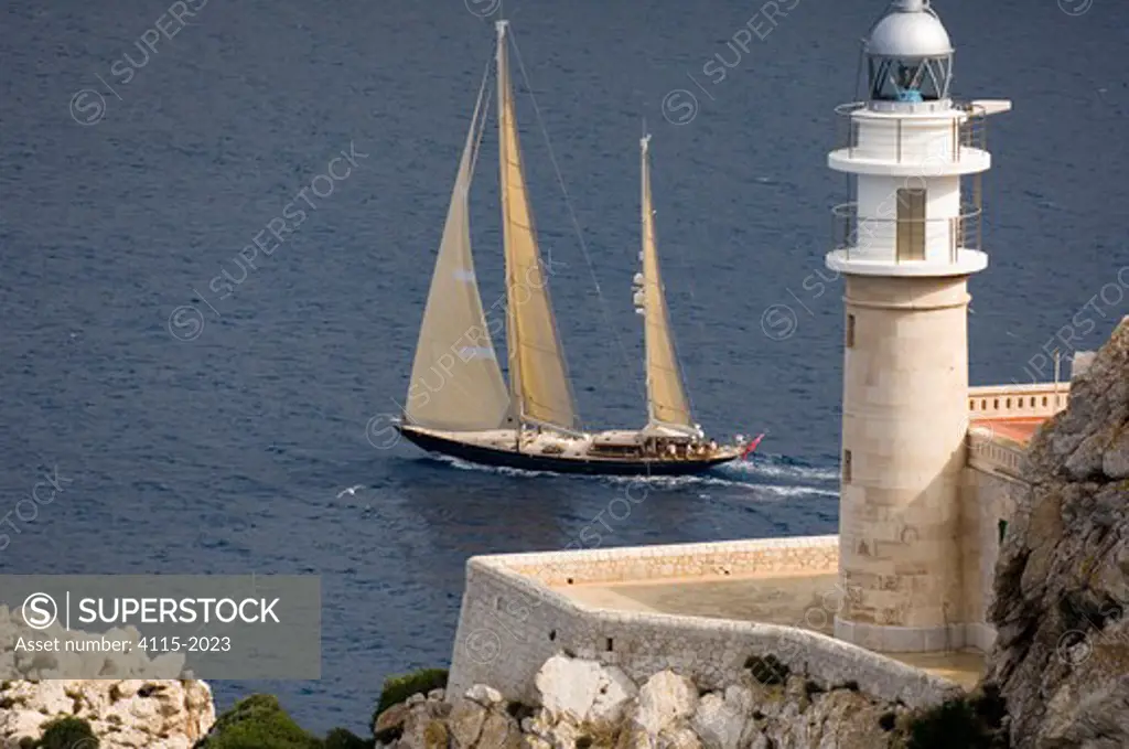 Sailing Yacht Velacarina photographed passing a lighthouse off the coast of Isla Dragonera, on the west end of Majorca Spain. Velacarina is a Andre Hoek Design Truly Classic 86. The image was taken in October 2006.