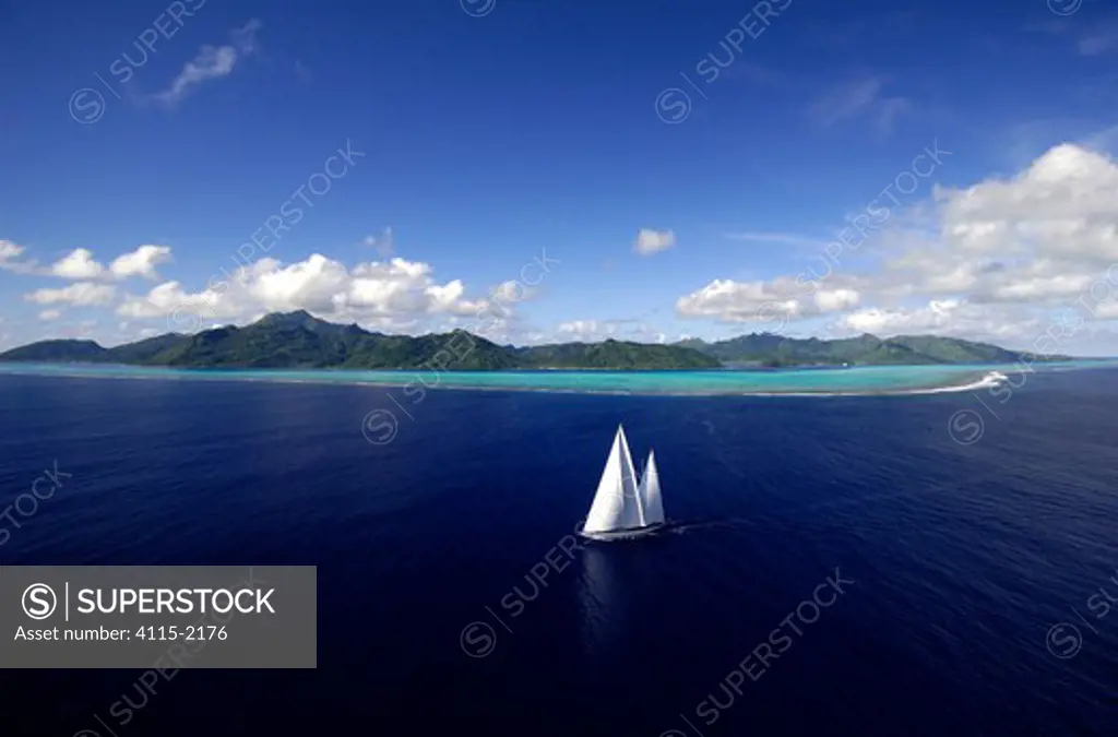 Aerial view of SY 'Adele', 180 foot Hoek Design, underway close to the reef off Huahine Island, French Polynesia