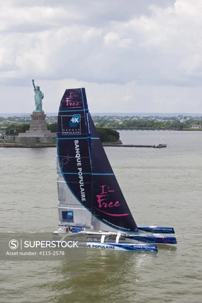 Maxi trimaran 'Banque Populaire V', skippered by Pascal Bidgorry, arriving in Manhattan, New York, for North Atlantic record attempt. Passing the Statue of Liberty, 27 June 2009.