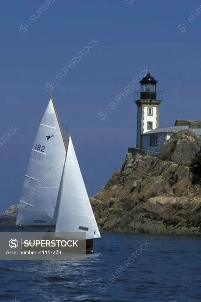 Sloop sailing past lighthouse, L'ille Louet, Bay of Morlaix, Finistere, Brittany, France
