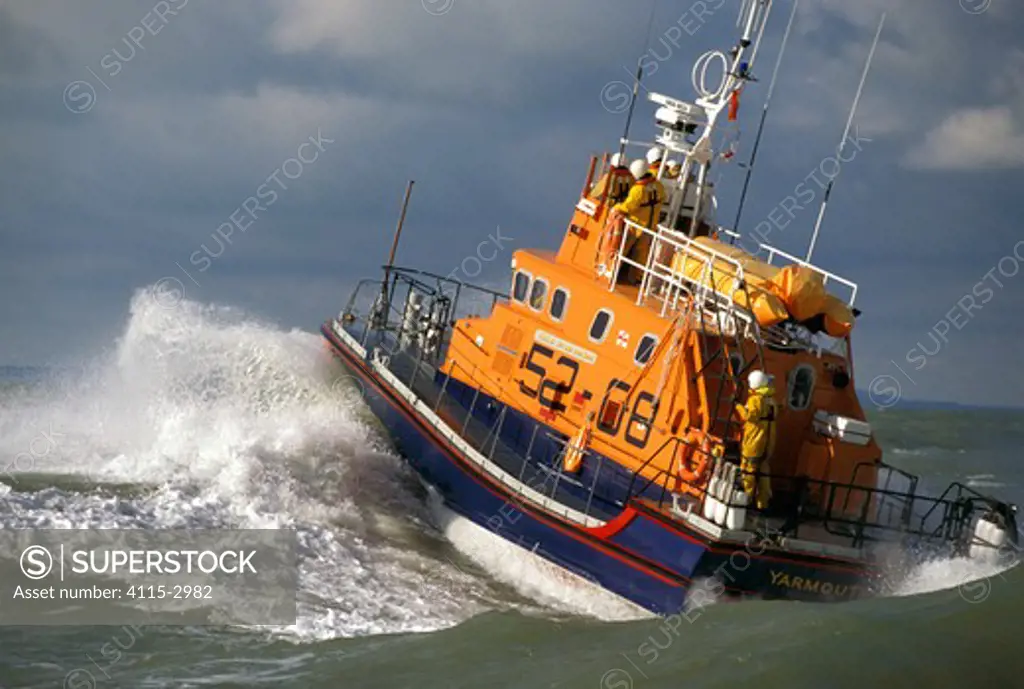 The Yarmouth, IOW Lifeboat powers through the waves in the Solent, the crew can be clearly seen on deck.
