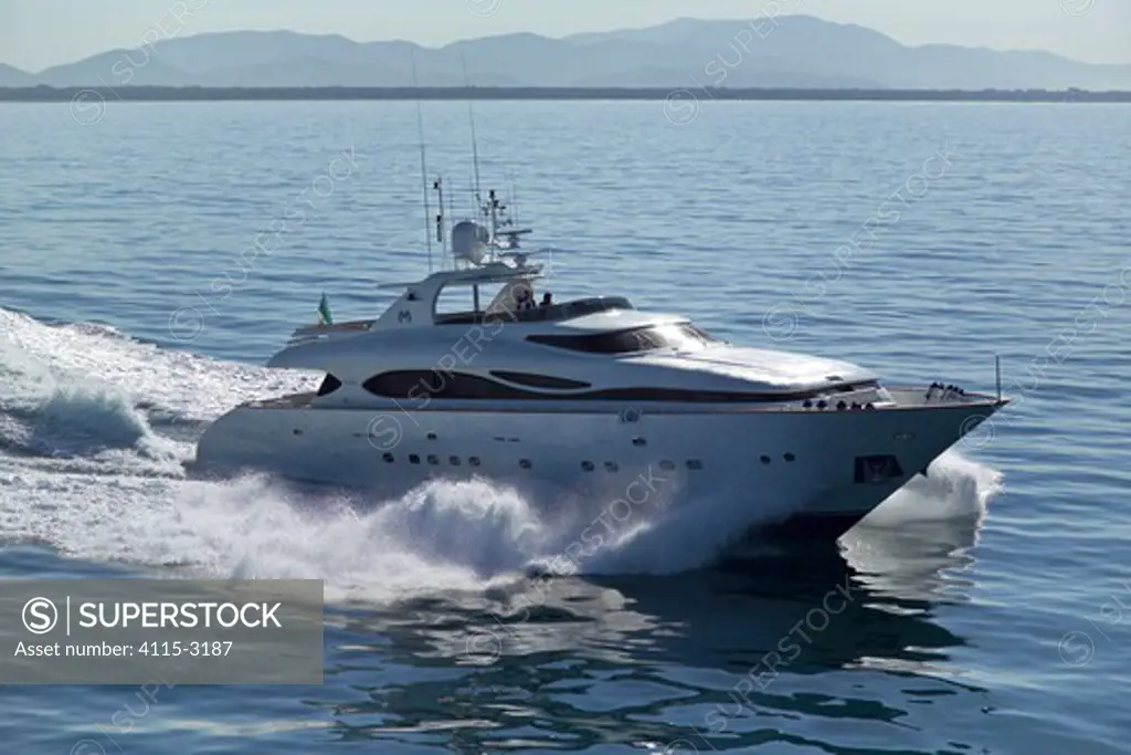 Luxurious 35-metre Gaia motoryacht, a model from the Cantieri Maiora boathouse, cruising along the mountainous coast of Viareggio, Italy.